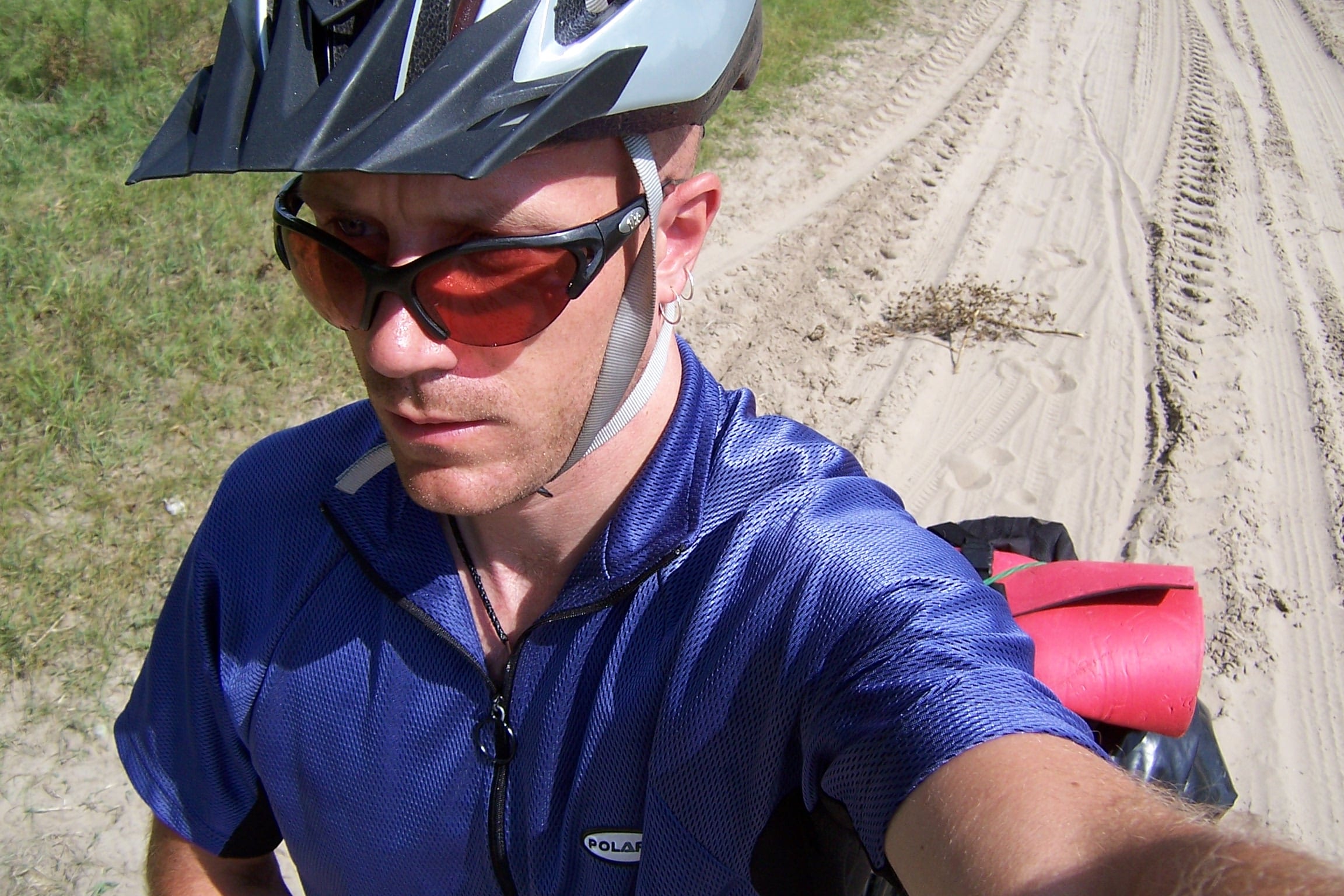 A not so happy Dave Briggs pushing his bike through sand whilst cycling from Budapest to Carta.