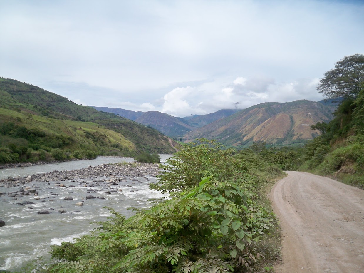 Cycling along a dirt road which follows a river near San Ignacio, Peru
