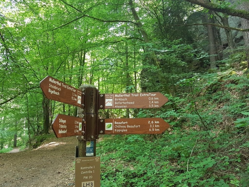 A signpost marking the Mullerthal Trail in Luxembourg along with some other local routes