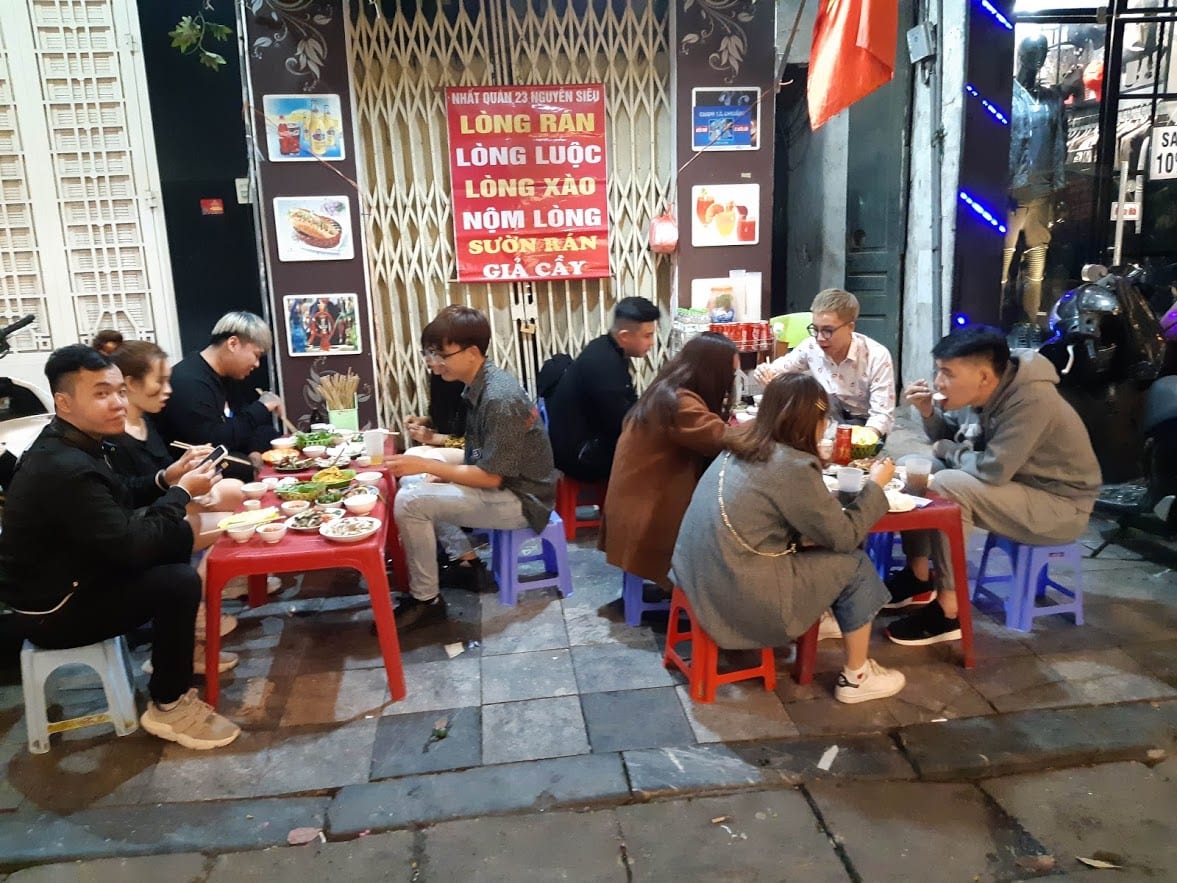 Eating street food in Hanoi whilst sitting on the small plastic chairs and tables.
