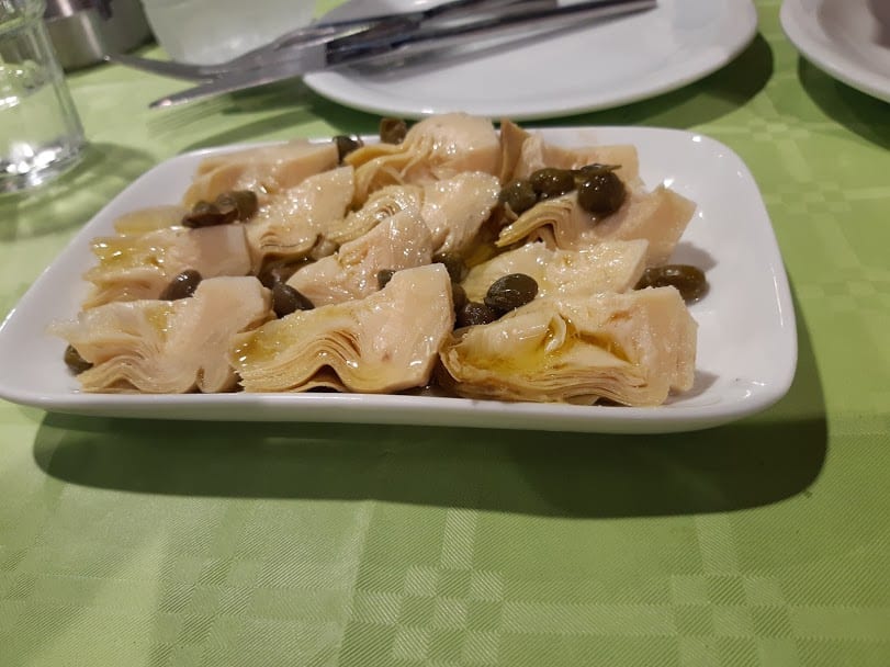 Eating marinated artichokes in Tinos island Greece