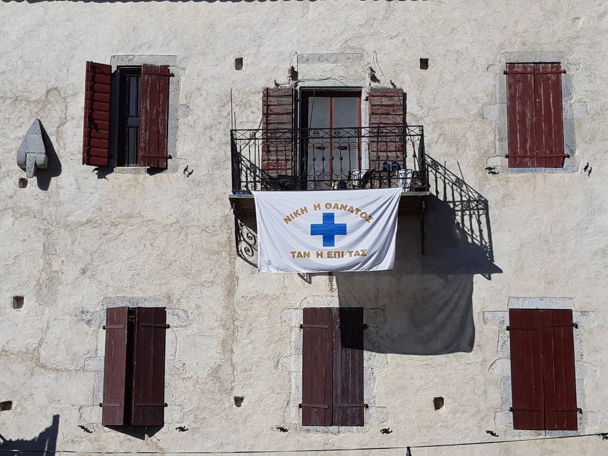 Greek revolution flag on siplay outside a house near Arepoli