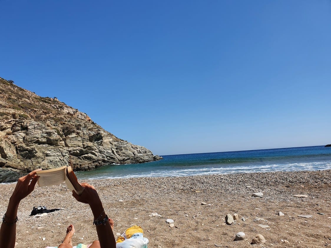 Reading a book on the beach in Sikinos Greece
