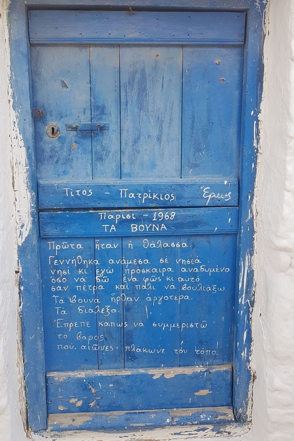 A door with Greek poetry written on it as seen in Tinos island in Greece