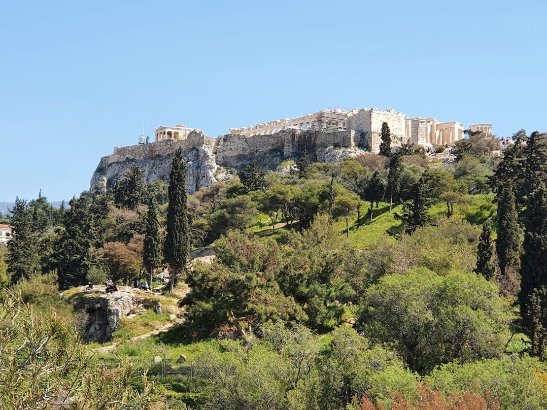The Acropolis of Athens surrounded by greenery on a spring day