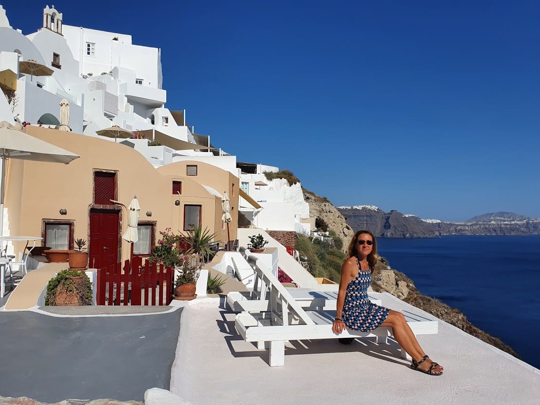 Vanessa sitting at a romantic setting in Santorini Greece